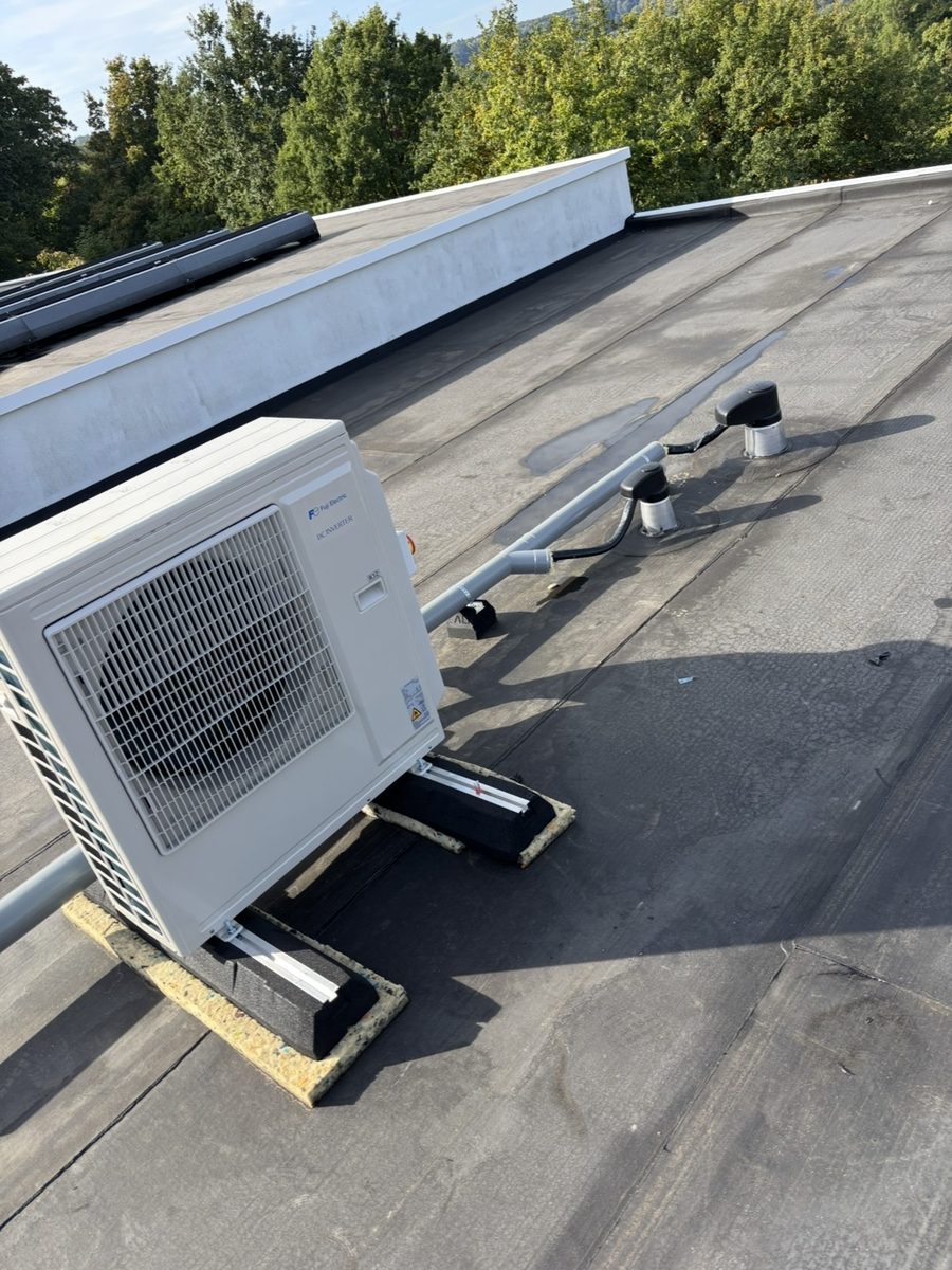 Fuji Electric buitenunit op een plat dak op trillingsdempers